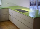 Küche mit grüner Arbeitsplatte und Linoleum Fronten