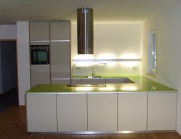 Küche mit grüner Arbeitsplatte und Linoleum Fronten